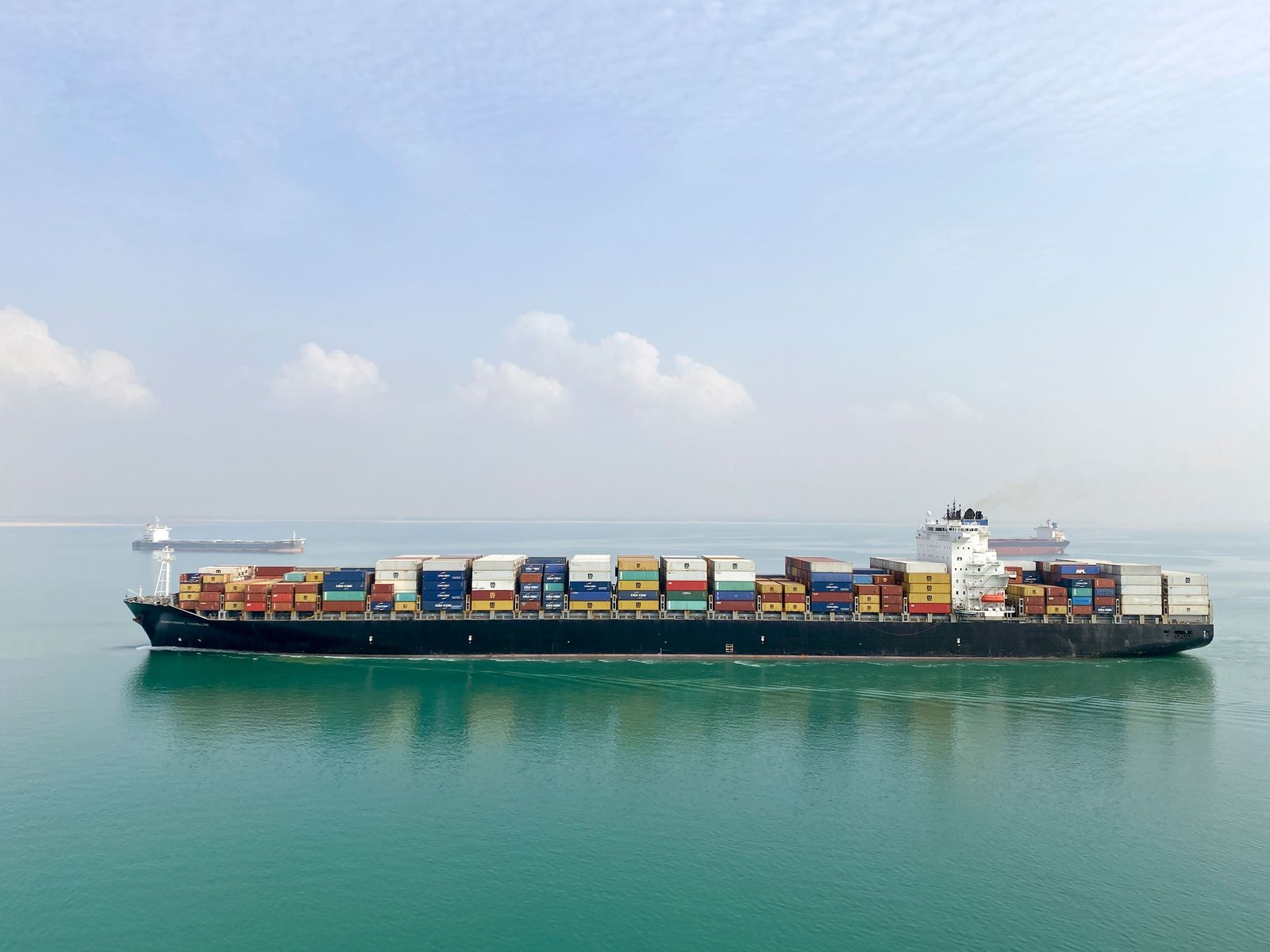 Transport aerian și maritim – navă portcontainer încărcată cu containere pe mare