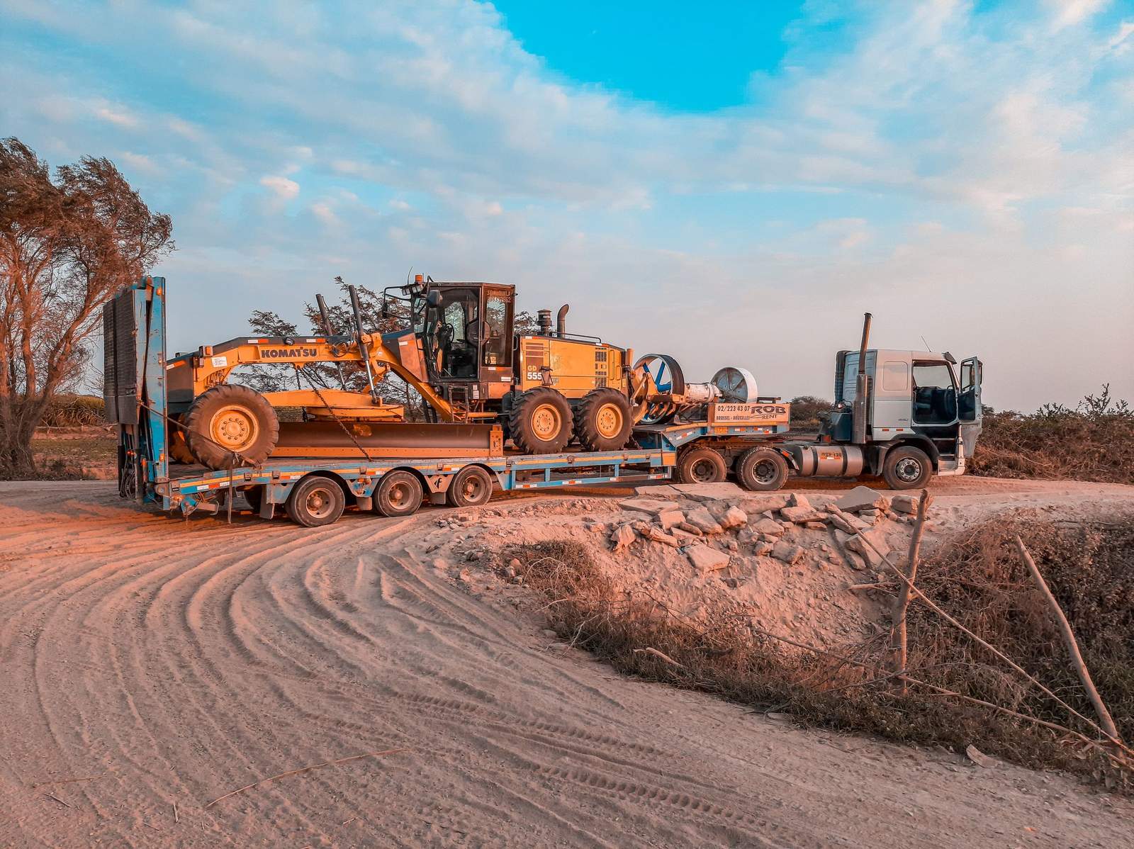 Transport agabaritic – utilaj greu încărcat pe trailer cu platformă joasă